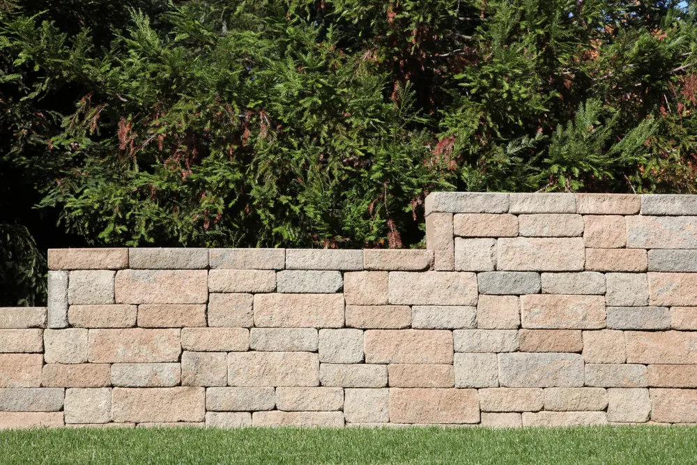 Stacked concrete block retaining wall in a landscaped yard Concord NC — The Concord Concrete Company